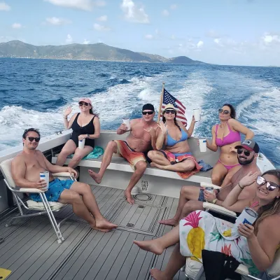 a group of people sitting next to a body of water