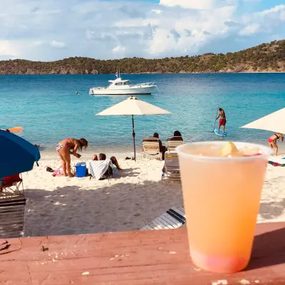 a table topped with a blue umbrella sitting on top of a beach