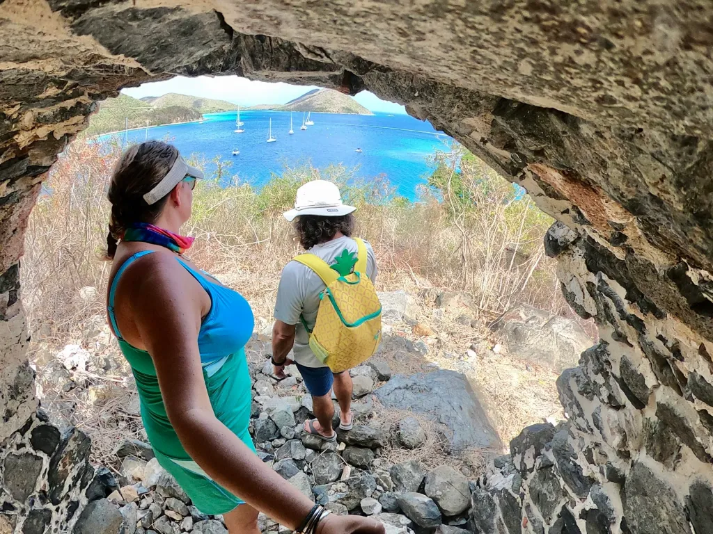 a person sitting on a rock next to a body of water