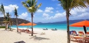 a group of lawn chairs sitting on top of a sandy beach