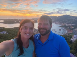 a person standing in front of a body of water posing for the camera