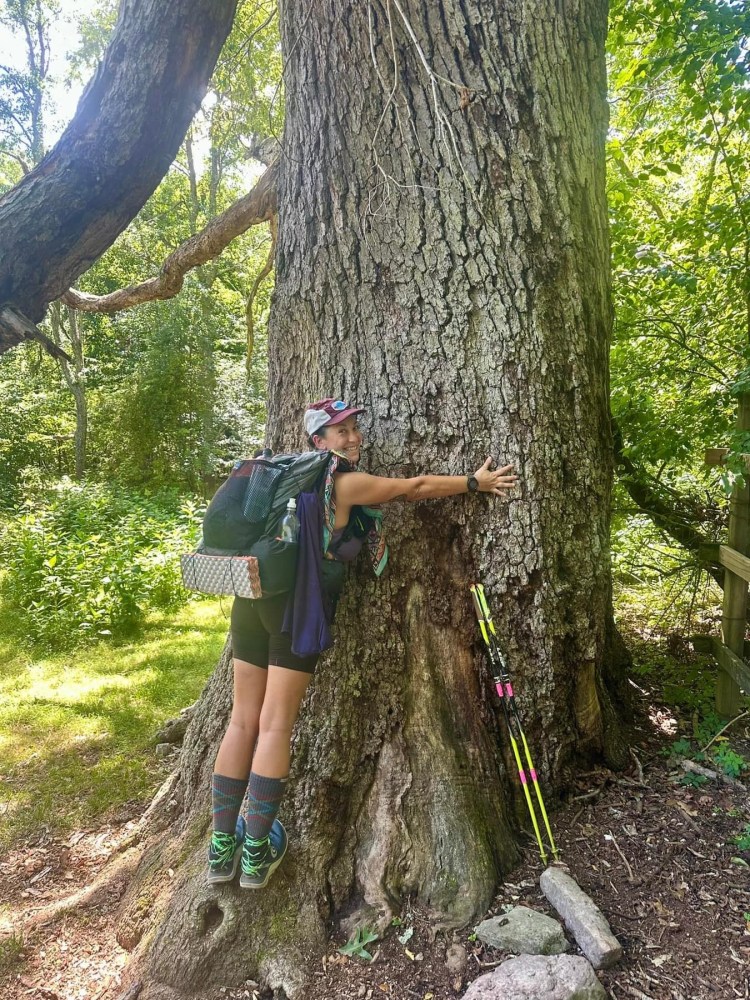 a person standing next to a tree