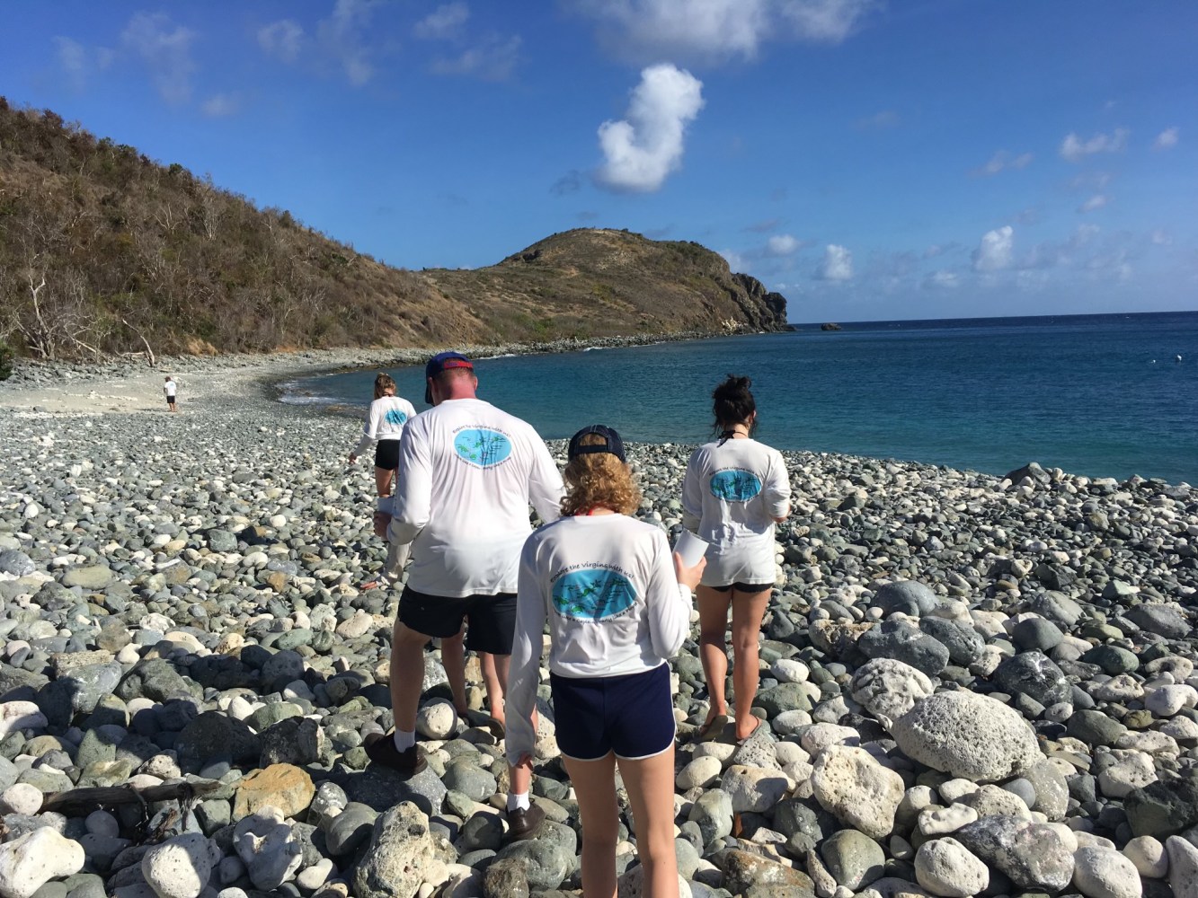 a group of people standing on a rocky beach