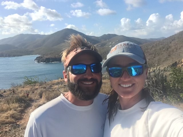 a person wearing sunglasses and standing in front of a mountain