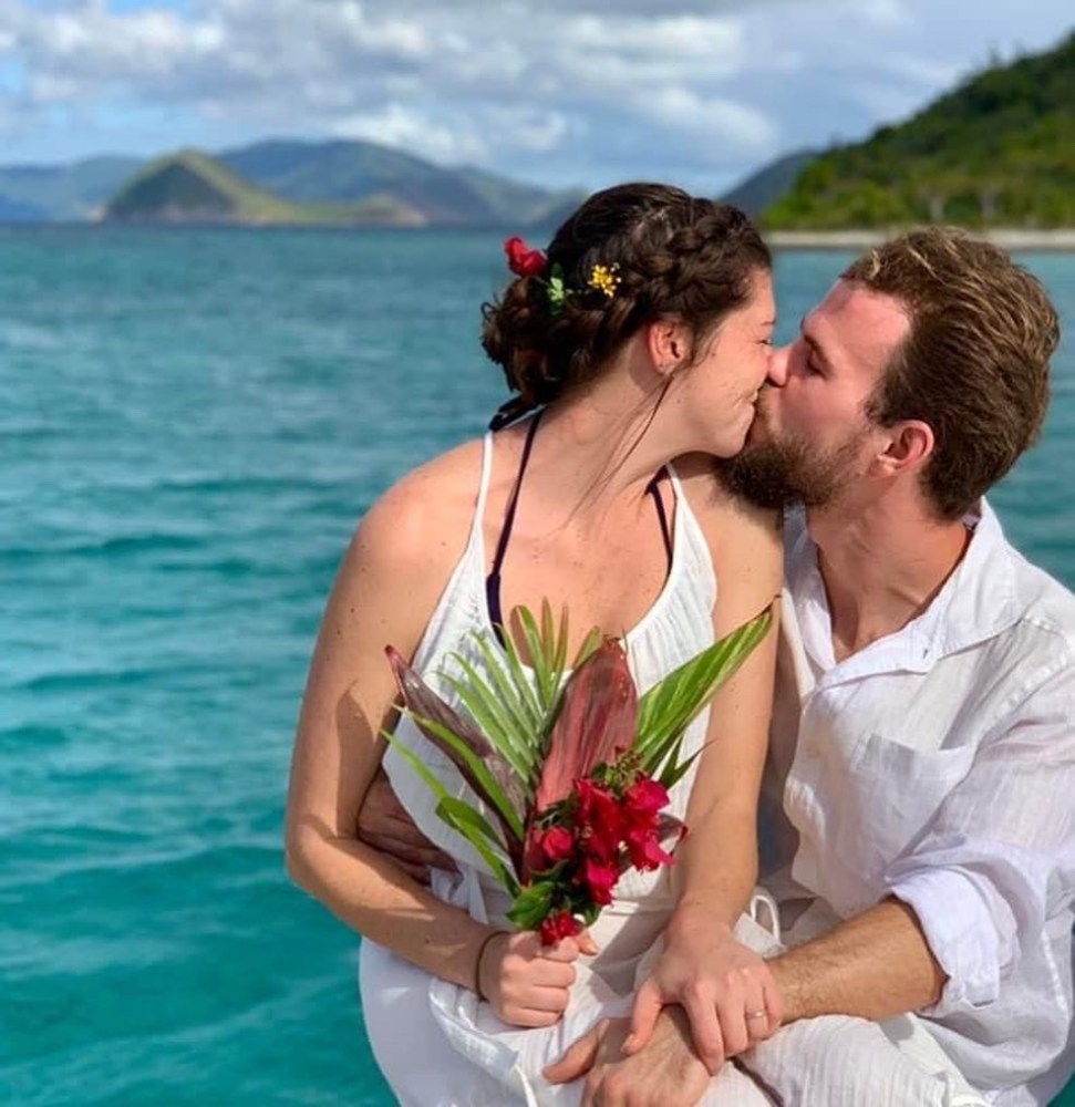 a man and a woman standing in front of water