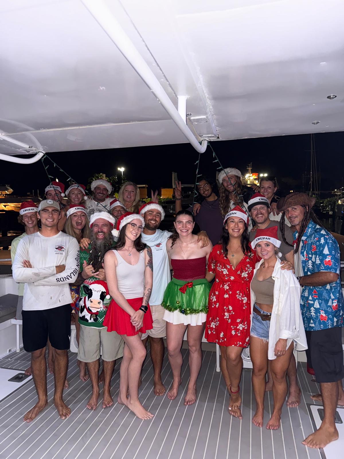 Group of people in Christmas attire on a boat at night.