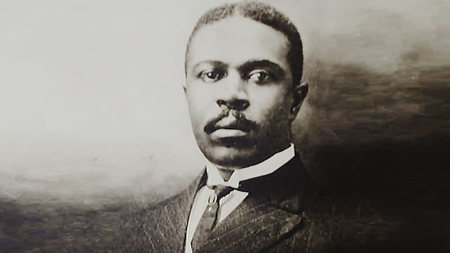 Black and white portrait of a man in a suit and tie.